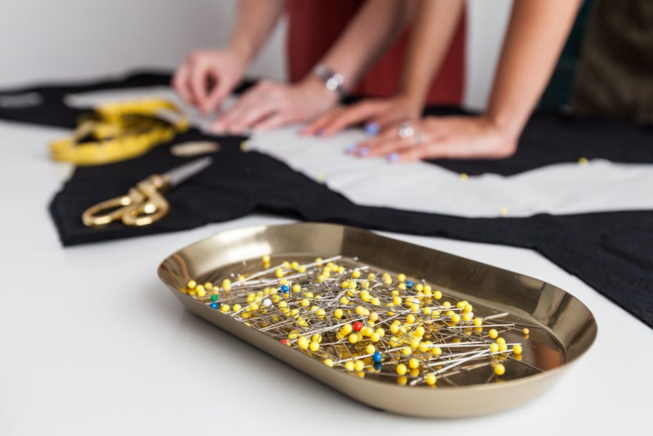 Sewing atelier scene with dressmakers working on fabric with sewing pins, showcasing detailed craftsmanship.